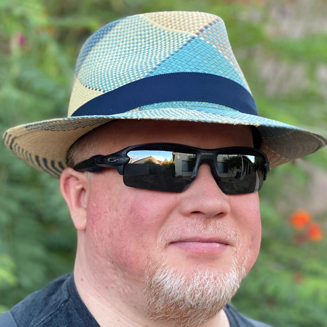 Profile photo of Joe Martin. Looking into the camera, wearing dark sunglasses, and a dapper straw hat. The hat has light blue highlights and a dark blue band around the crown.